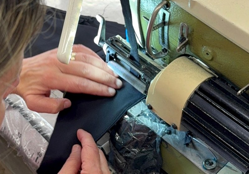 Close-up of the black Vicky Baey Essential Tucking Thong being edge-bound on an industrial sewing machine in the family-run atelier in Trofa, Portugal.