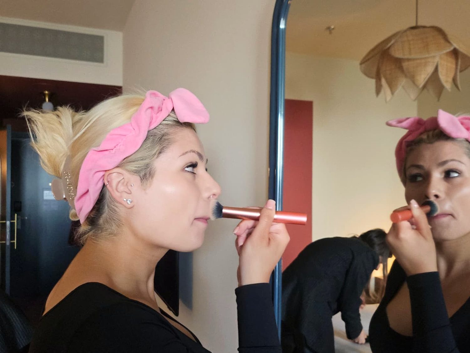 Andrea getting ready in front of a mirror before the Vicky Baey photoshoot.