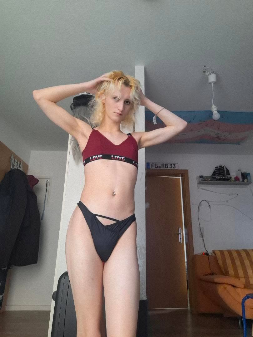 Natalie wearing the black Vicky Baey Essential Tucking Thong, with her hands in her hair.