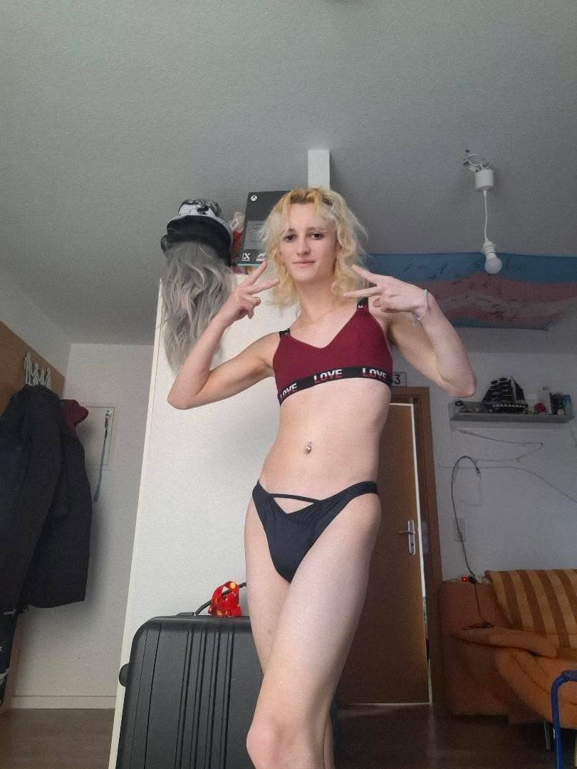 Natalie wearing the black Vicky Baey Essential Tucking Thong, making peace signs.